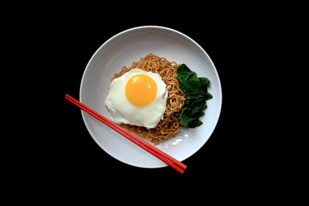 Photo tasty fried noodle with sunny side up egg, and vegetable. served on white plate