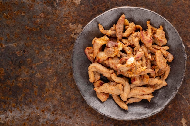 Tasty fried pork fillet in wabi sabi plate on rusty texture background with copy space for text top view flat lay