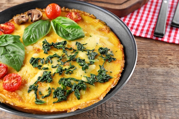 Tasty frittata with spinach on table