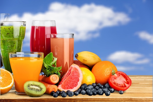 Tasty fruits and juice on desk