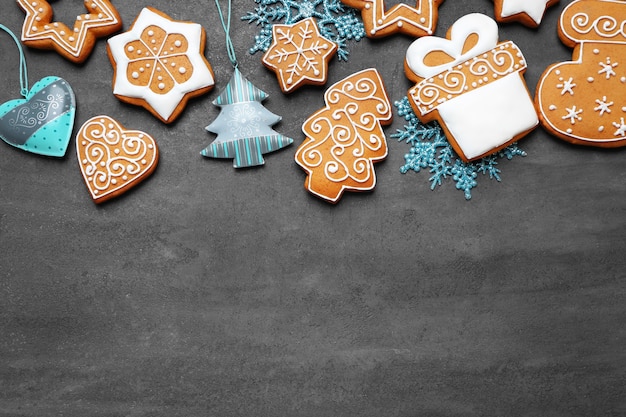 Tasty gingerbread cookies and Christmas decor on grey background