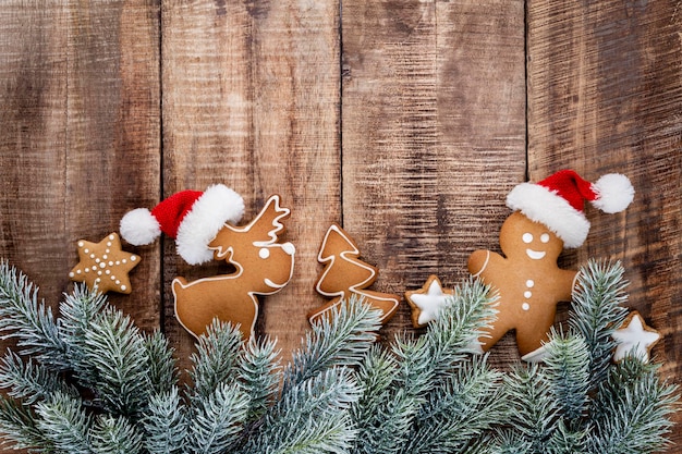 Tasty gingerbread cookies and Christmas decor on pastel background.