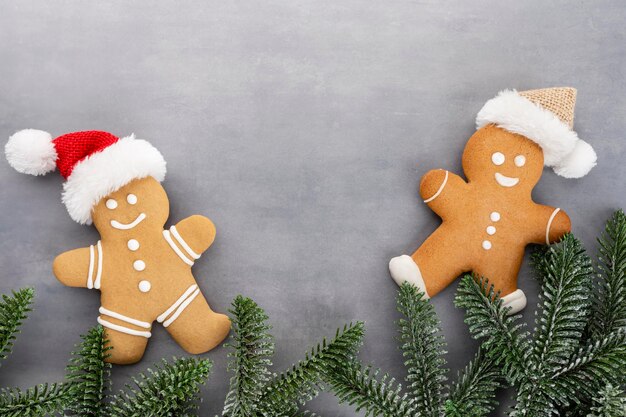 Tasty gingerbread cookies and Christmas decor on pastel background.