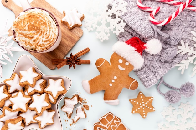 Tasty gingerbread cookies and Christmas decor on pastel background.