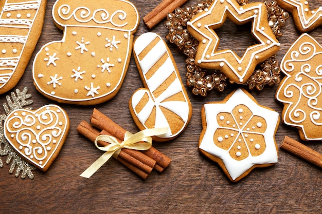 Tasty gingerbread cookies and Christmas decor on wooden background, close up