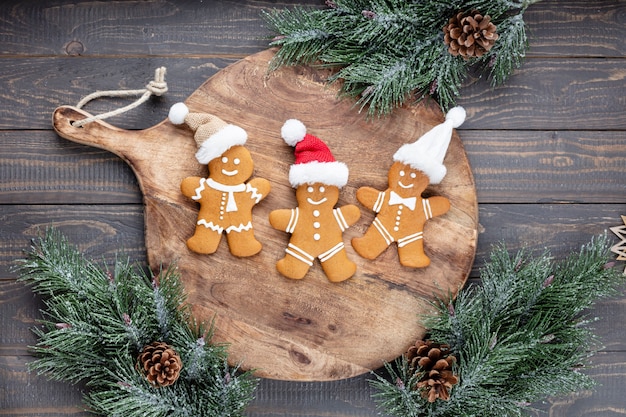 Tasty gingerbread cookies and Christmas decor on wooden background.