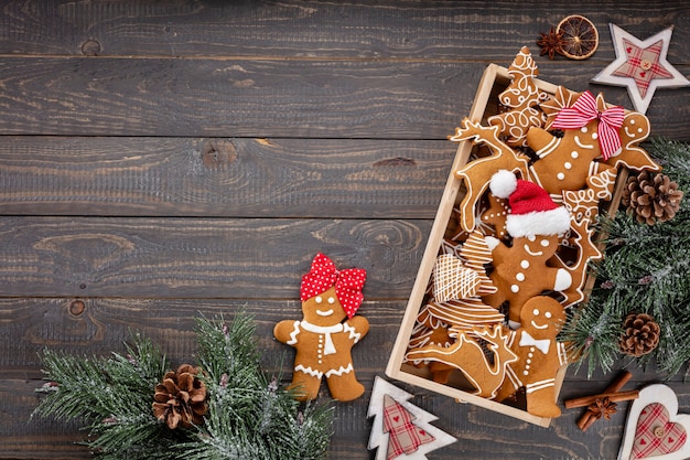 Tasty gingerbread cookies and Christmas decor on wooden background.