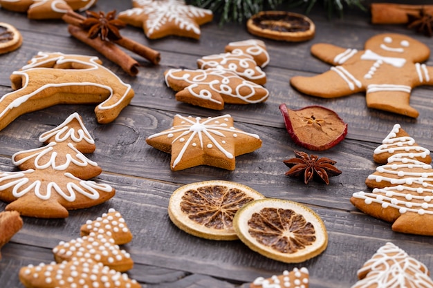 Tasty gingerbread cookies and Christmas decor on wooden background.