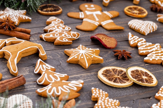 나무 배경에 맛있는 진저브레드 쿠키와 크리스마스 장식이 있습니다.