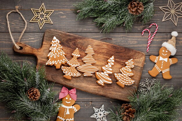 Tasty gingerbread cookies and Christmas decor on wooden background.
