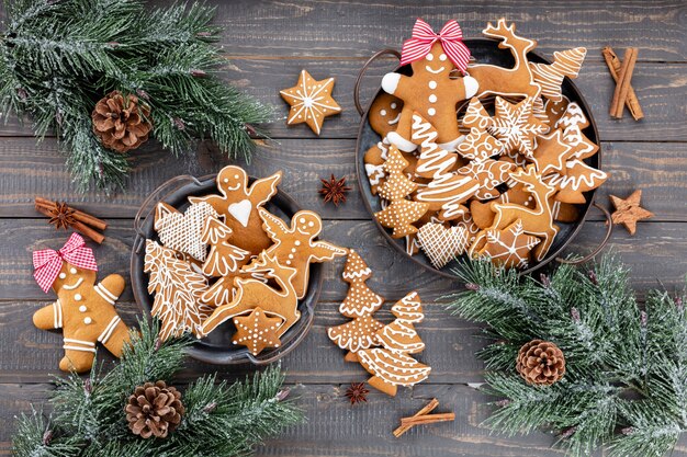 Tasty gingerbread cookies and Christmas decor on wooden background.