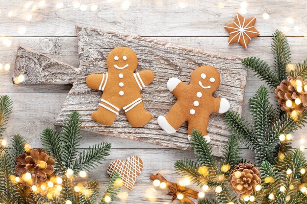 Tasty gingerbread cookies and Christmas decor on wooden background.