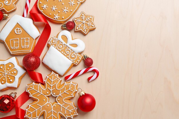 Tasty gingerbread cookies and Christmas decor on wooden background