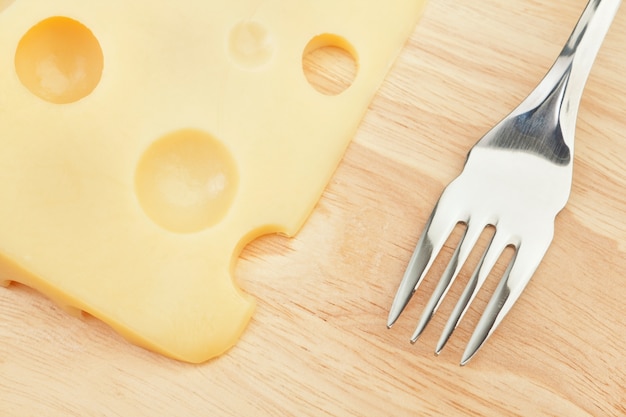 Tasty-grade cheese on a board with a fork. Concept.