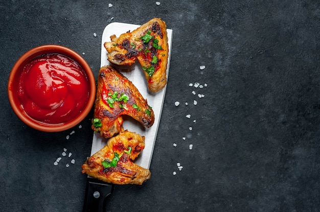 Tasty grilled chicken wings with spices and herbs