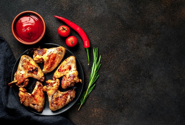 Tasty grilled chicken wings with spices and herbs