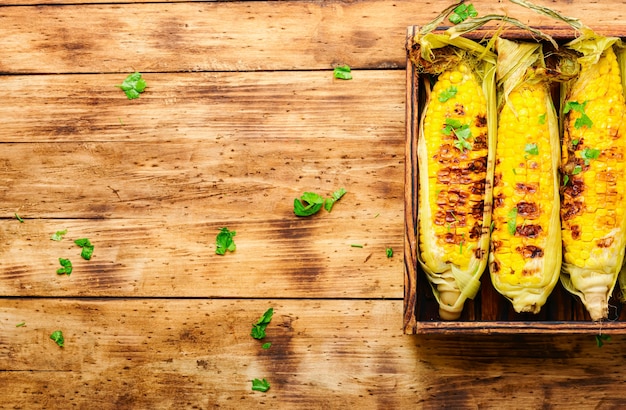 Tasty grilled corn on retro wooden table,summer food