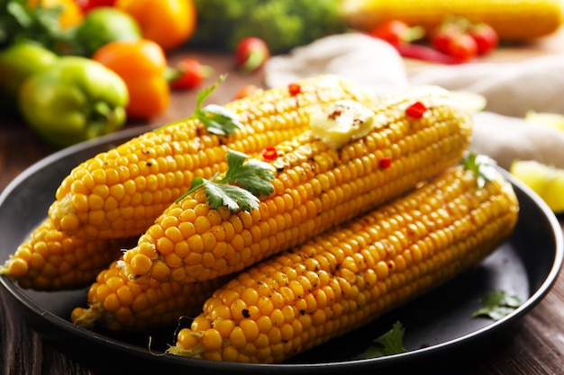 야채와 신선한 버터를 곁들인 맛있는 구운 옥수수 클로즈업