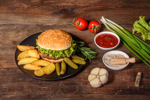 Tasty grilled homemade burger. Delicious grilled burgers. Craft beef burger and french fries on wooden table