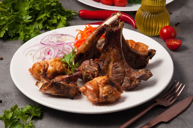 Tasty grilled meat platter lamb and chicken served with onions and carrots