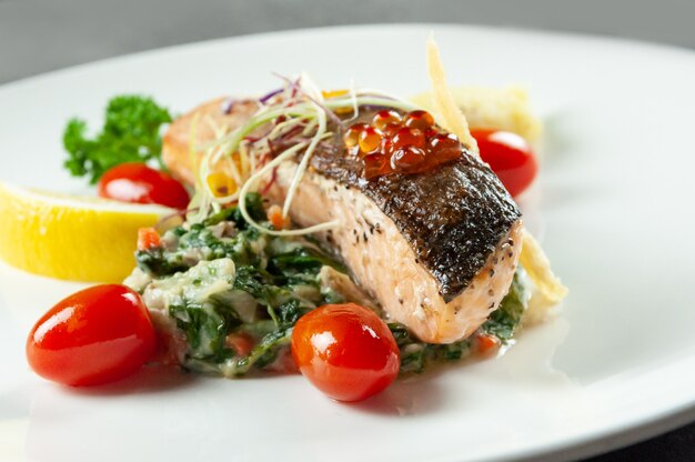 Tasty grilled salmon steak with spinach