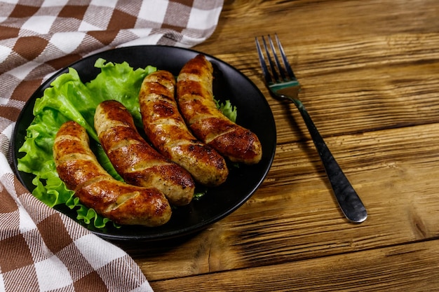 Tasty grilled sausages on a wooden table