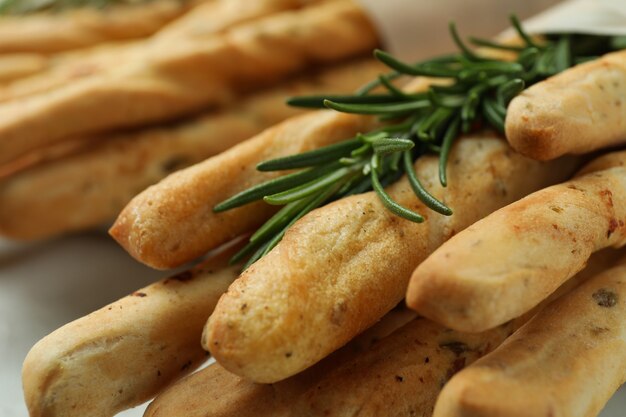 Tasty grissini sticks with rosemary, close up