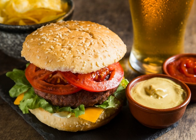 Foto gustoso hamburger con un bicchiere di birra e senape