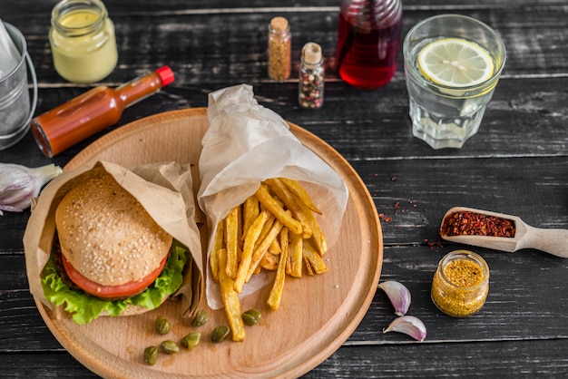 Gustoso hamburger con carne e verdure contro uno sfondo scuro. fast food. può essere usato come sfondo