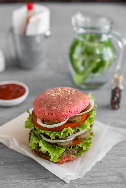 Tasty hamburger with meat and vegetables against a dark background. Fast food. It can be used as a background