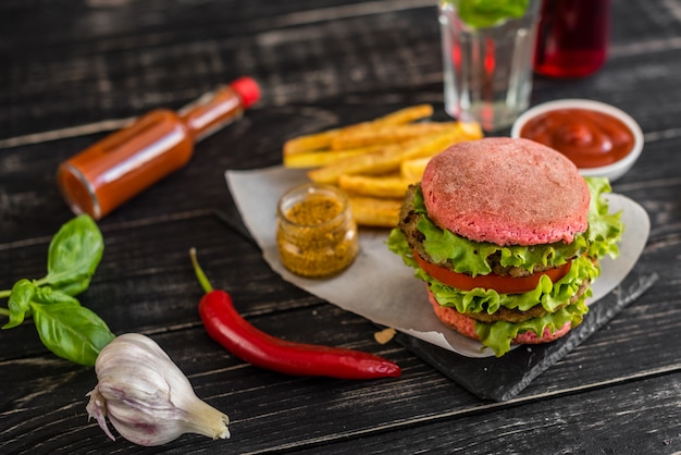 Tasty hamburger with meat and vegetables against a dark background. Fast food. It can be used as a background