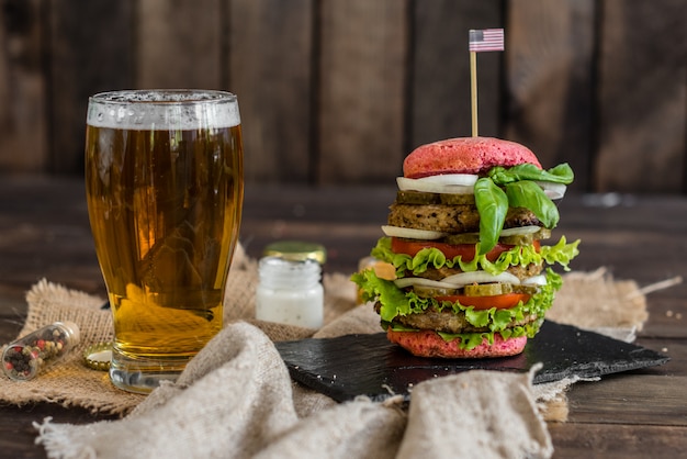 Photo tasty hamburger with meat and vegetables against a dark background. fast food. it can be used as a background