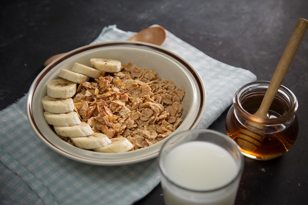 Tasty and healthy breakfast: fruits, corn flakes, milk and honey.