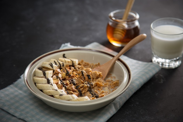 Tasty and healthy breakfast fruits, corn flakes, milk and honey.