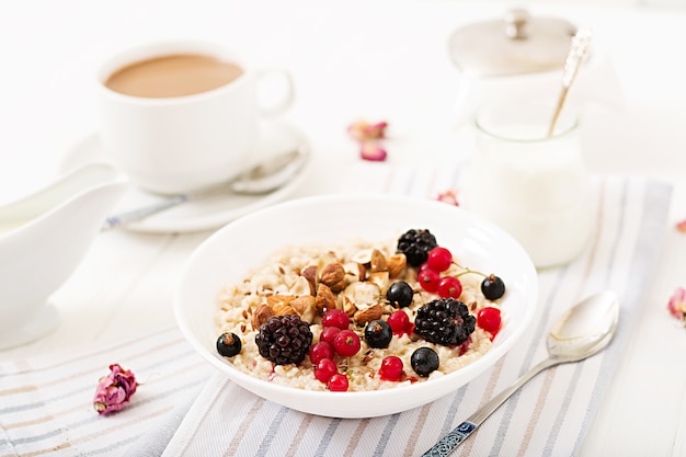 Tasty and healthy oatmeal porridge with berry, flax seeds and nuts. Healthy breakfast. 