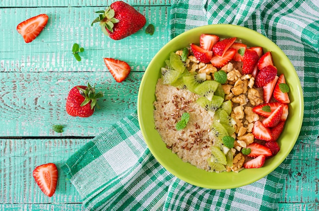 Tasty and healthy oatmeal porridge with berry, nuts and flax seeds. Healthy breakfast. Fitness food. Proper nutrition. Flat lay. Top view