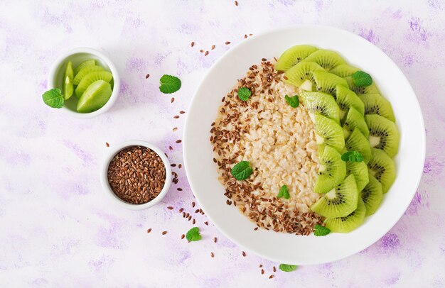 Tasty and healthy oatmeal porridge with kiwi and flax seeds. Healthy breakfast