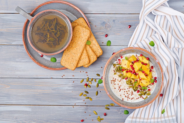 Porridge di farina d'avena gustoso e sano con mango, melograno e semi. colazione salutare. cibo fitness. nutrizione appropriata. vista dall'alto