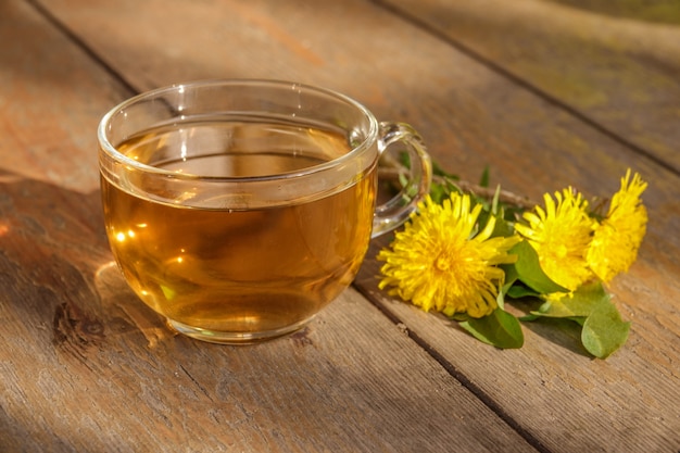 Photo tasty herbal tea in glass teapot on old wooden table