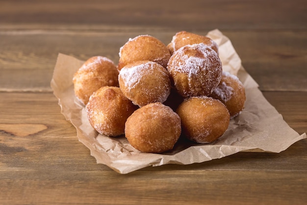 Gustose ciambelle di ricotta fatte in casa in polvere di zucchero sullo sfondo di legno ciambelle copia spazio in orizzontale