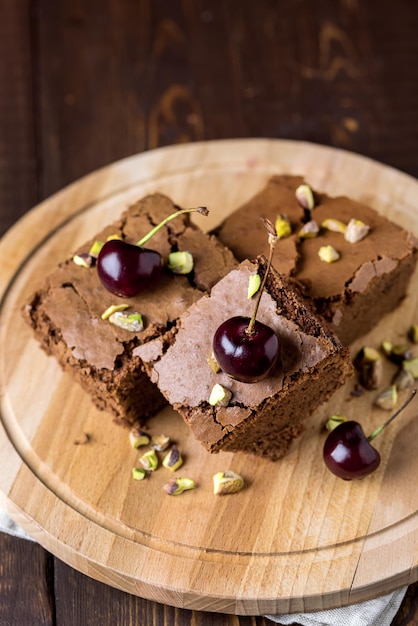 Tasty Homemade Dessert Chocolate Brownie Decorated with Berry and Nuts on Wooden Tray