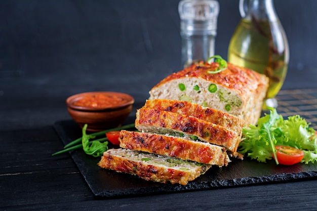 맛있는 수 제 지상 녹색 완두콩과 브로콜리 블랙 테이블에 닭고기 미트 로프를 구운. 음식 미국 미트 로프.