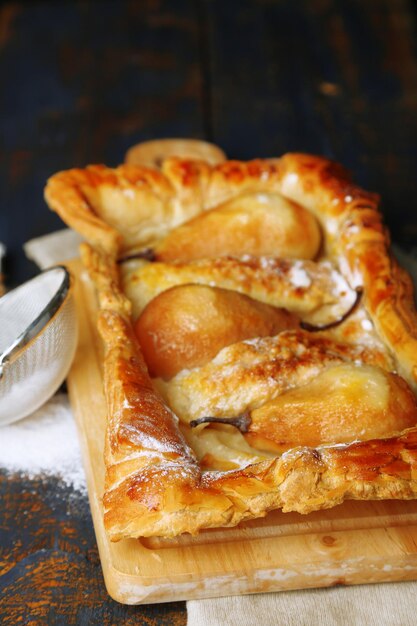 Tasty homemade pear pie on wooden table