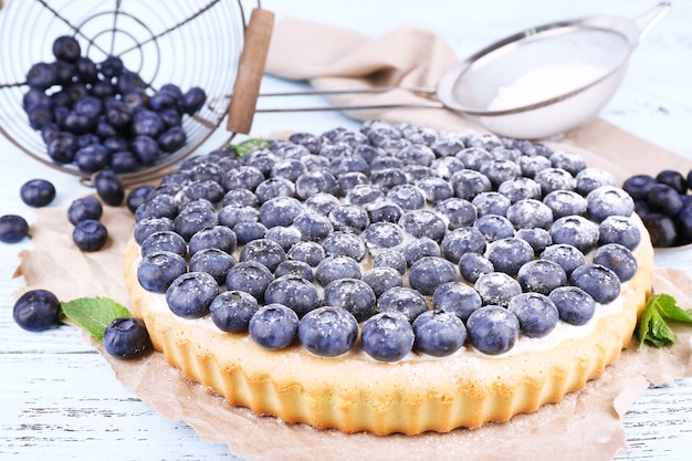 Tasty homemade pie with blueberries on wooden table