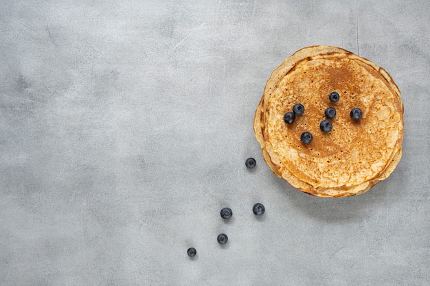 Tasty homemade rustic pancake on concrete background. Table top view. Maslenitsa food.