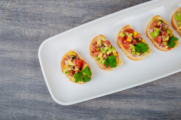 Tasty homemade sandwiches with avocado, tomato, onion and pepper