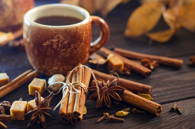 Tasty hot coffee with grains and spices on table