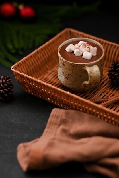 Tasty hot dark chocolate with sweets marshmallow in a minimal\
craft ceramic cup in a wicker basket o