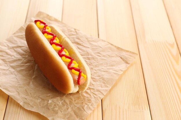 Tasty hot dog on wooden table