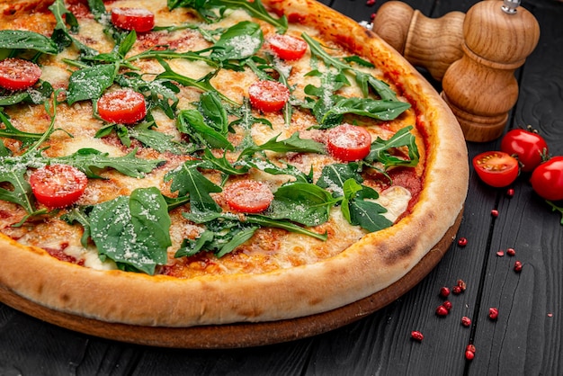 Tasty hot italian pizza on black wooden table